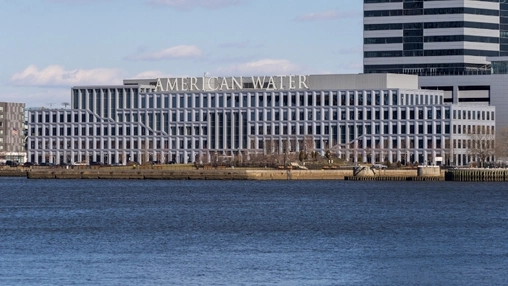 The American Water corporate building viewed from across a river with the company name visible on the facade