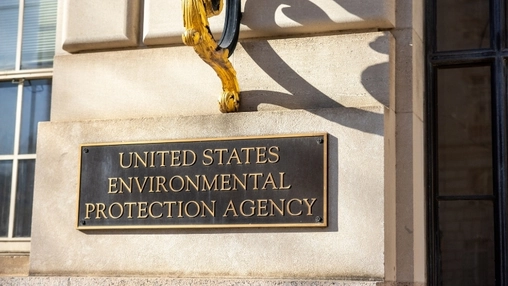 A bronze plaque reading Environmental Protection Agency is mounted on a stone building facade near a doorway