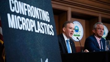 Officials testify at a hearing on microplastics beside a large Confronting Microplastics sign